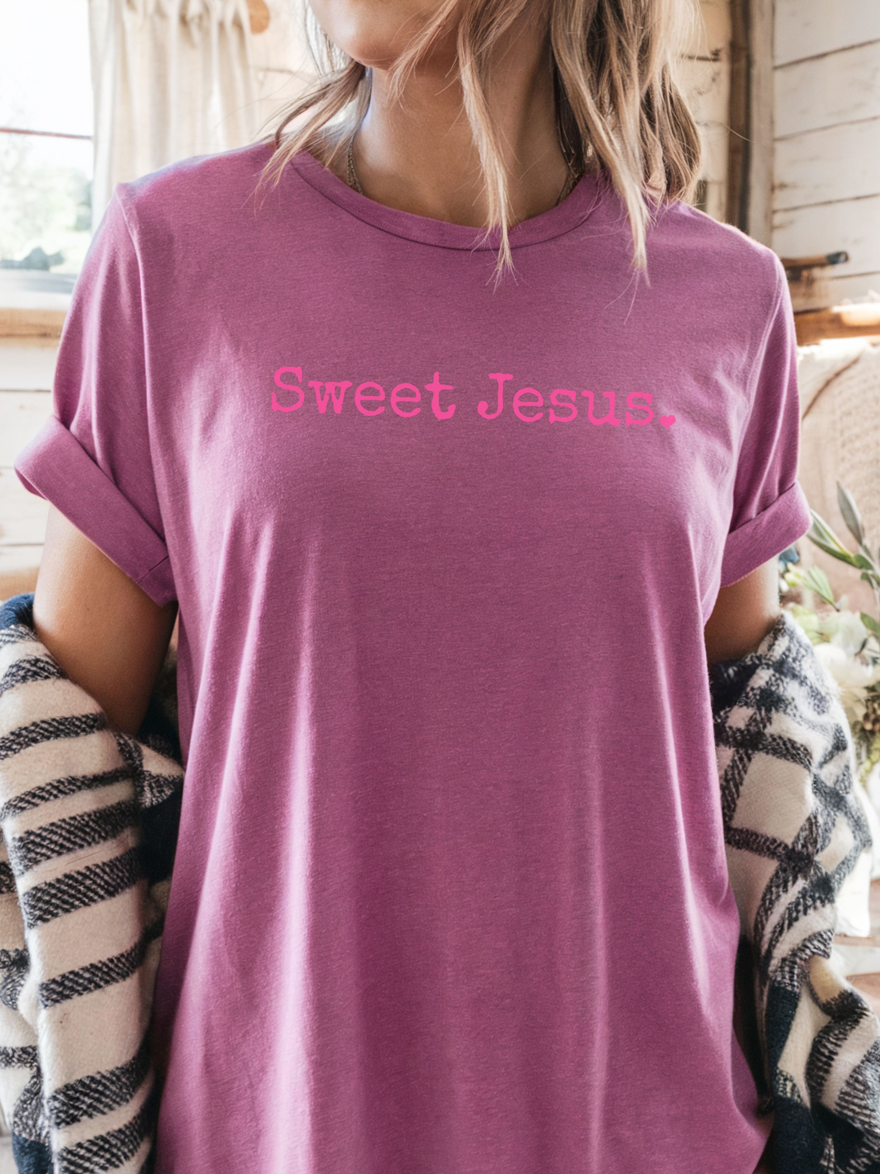 Person wearing a purple t-shirt with 'Sweet Jesus' text in pink.