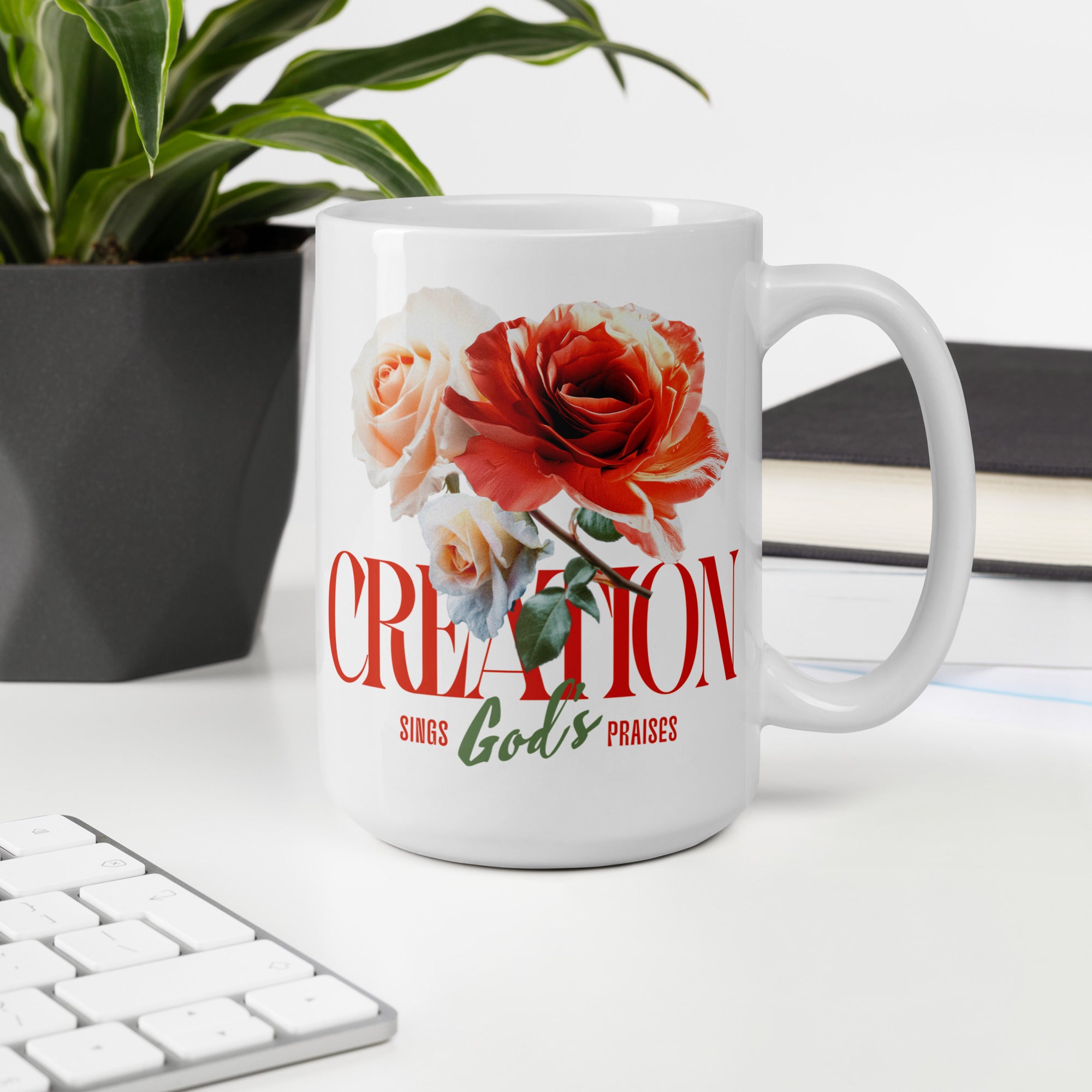 White mug with floral design and text on a desk with a plant and keyboard in the background