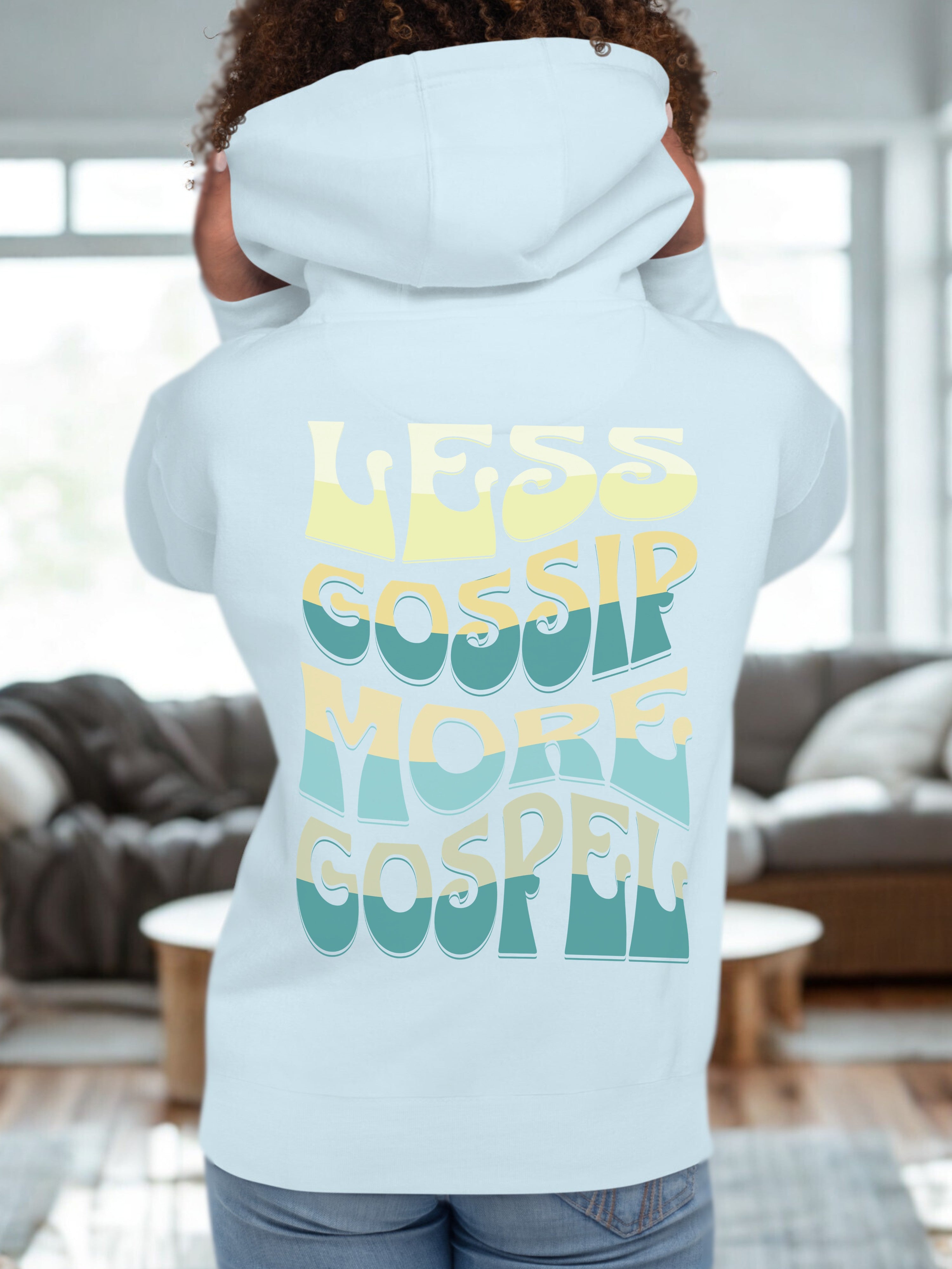 Light blue hoodie with text 'LESS GOSPEL MORE GOSPEL' on the back, worn by a person in a living room.