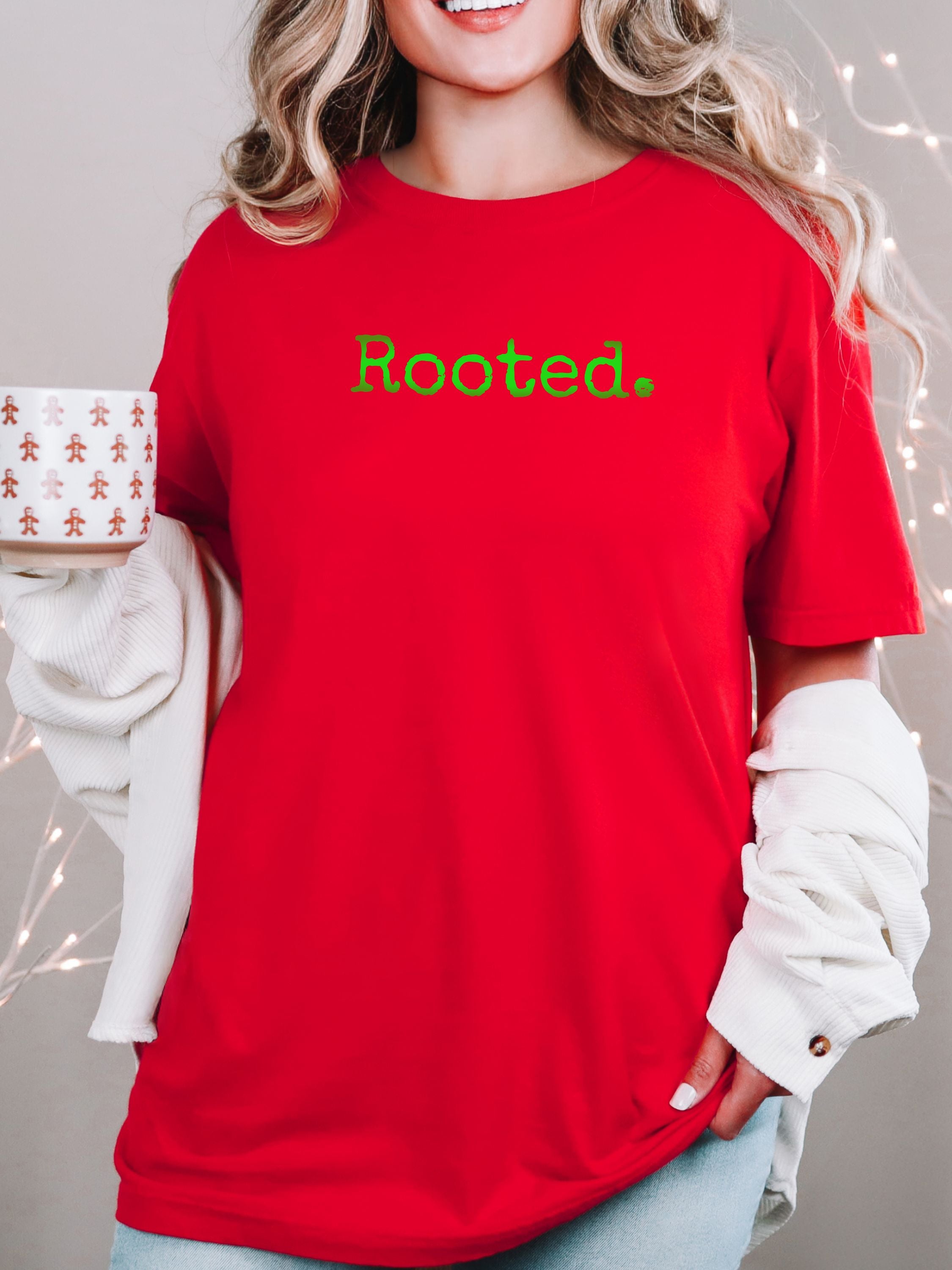 Female wearing a red t-shirt with 'Rooted.' text in shades of green, perfect for Christmas.