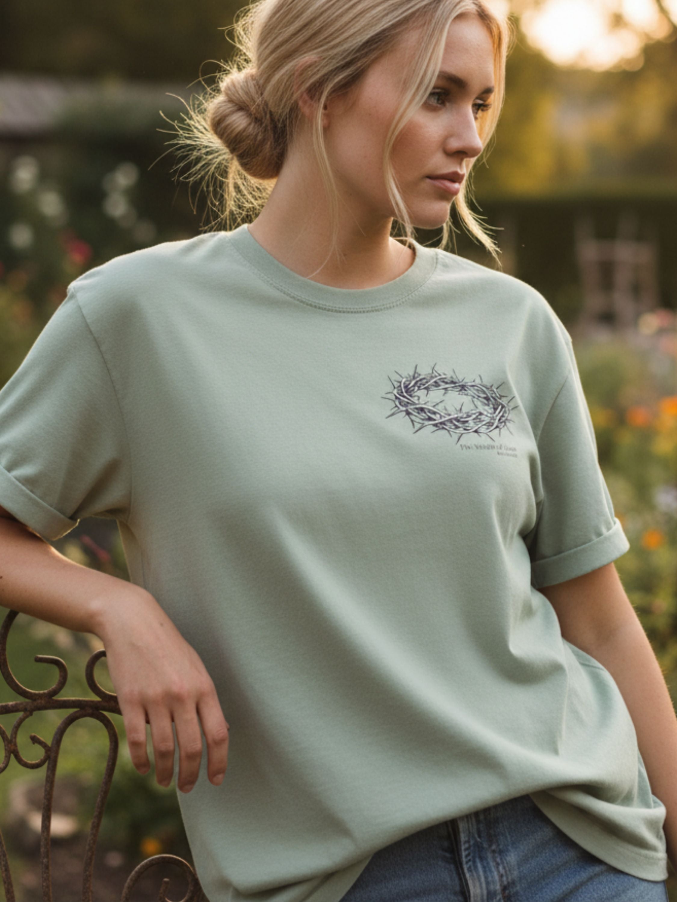 Woman wearing a light green t-shirt with a design outdoors